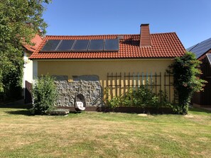 Traditional architecture with a focus on renewable energy and a well-manicured lawn.