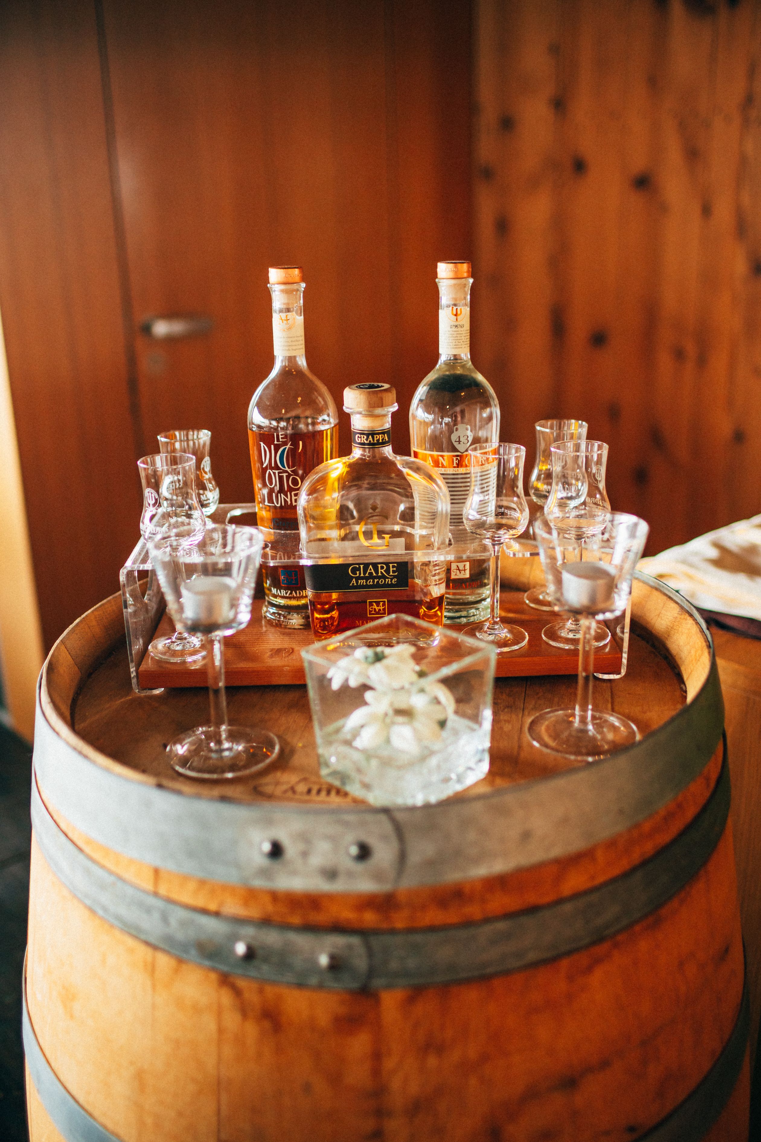Un barril de madera con diferentes botellas y vasos de licor.