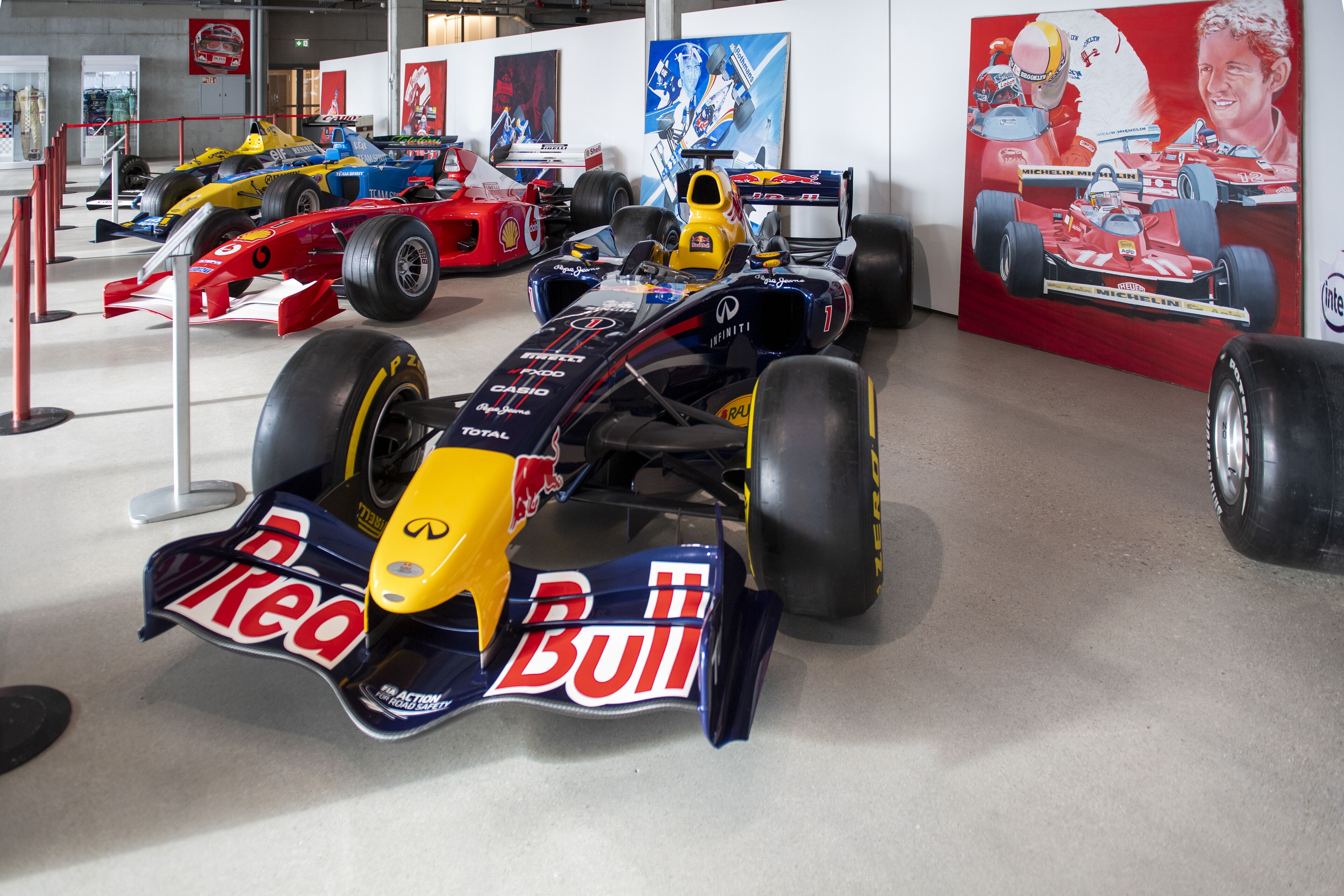 Une exposition de voitures de course présentant plusieurs modèles dans un espace d’exposition.