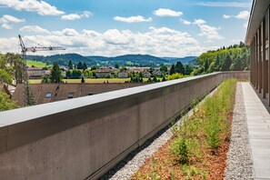 A concrete platform with a view of a train track and distant buildings. - Hotel Meilenstein (Langenthal)