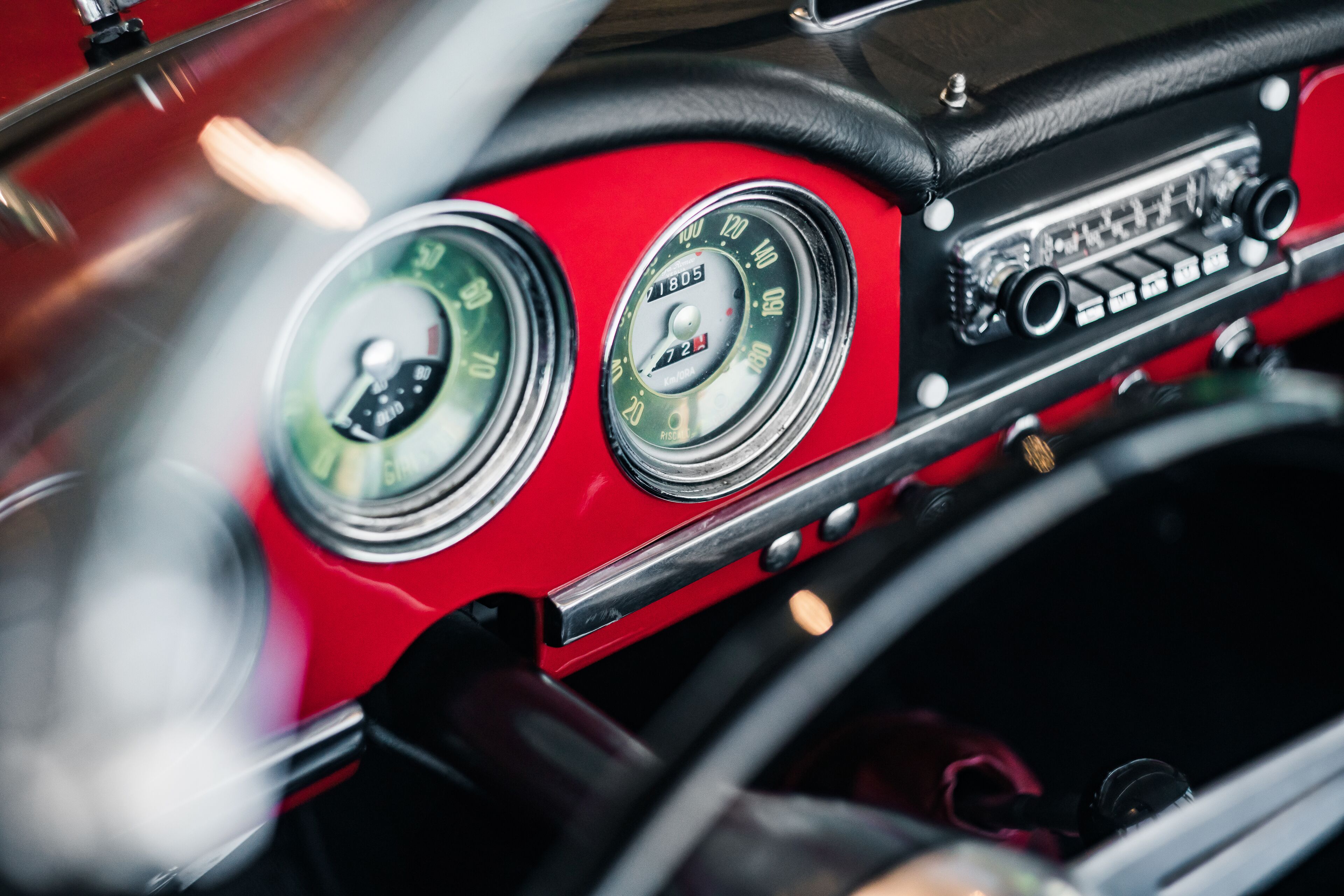 Un tableau de bord de voiture classique, doté d’instruments analogiques et d’une radio d’époque.