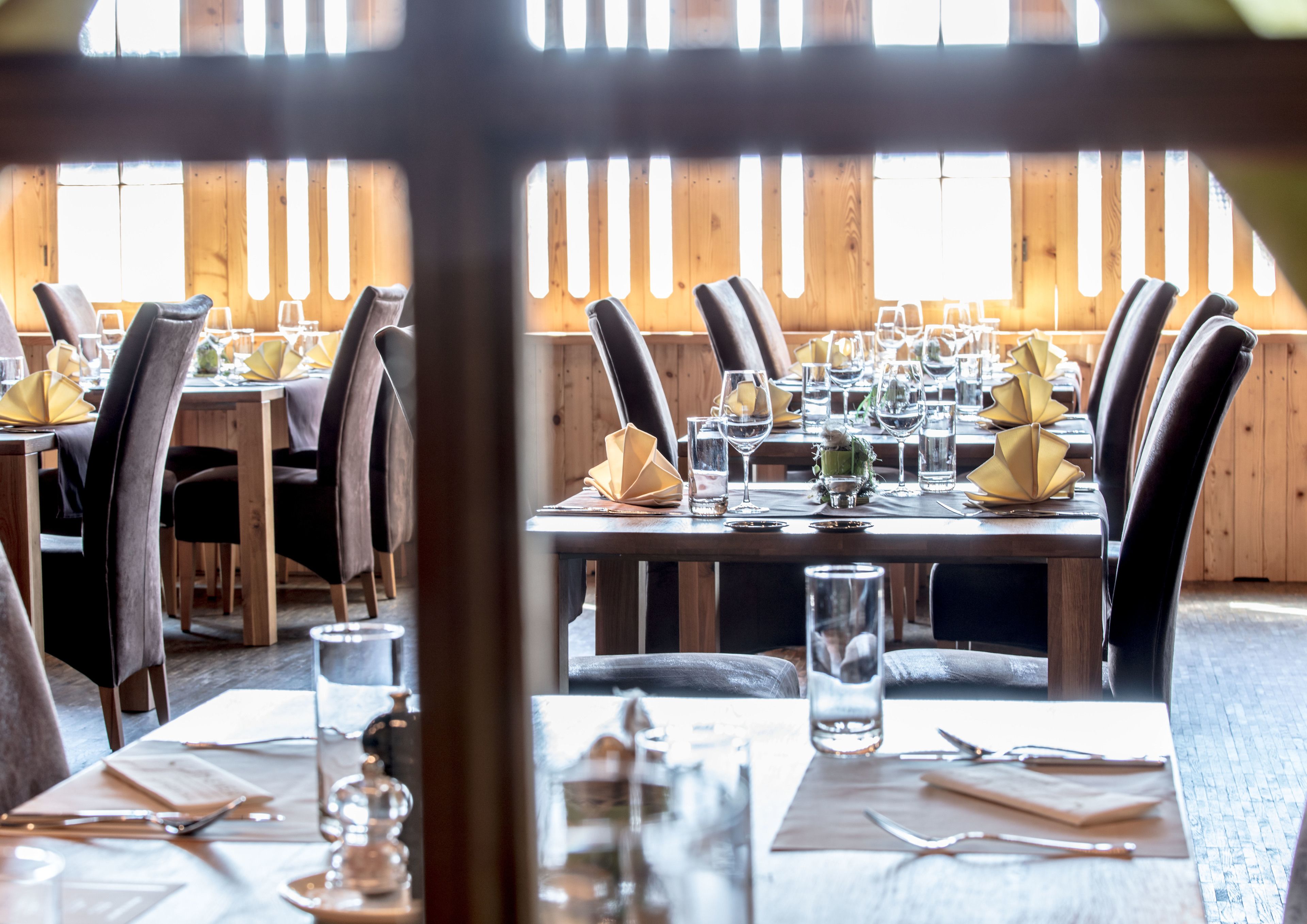 A restaurant with wooden walls and tables set for dining.