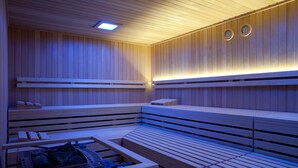 Un sauna avec des bancs en bois et une table prévue pour être utilisée dans le sauna.