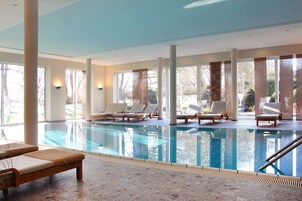 Una piscina techada, sillones reclinables de piscina