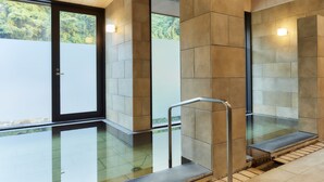 A modern bathroom with a glass shower enclosure, a metal handrail, and a tiled floor. - Amagase Onsen Seitenkaku (Hita)