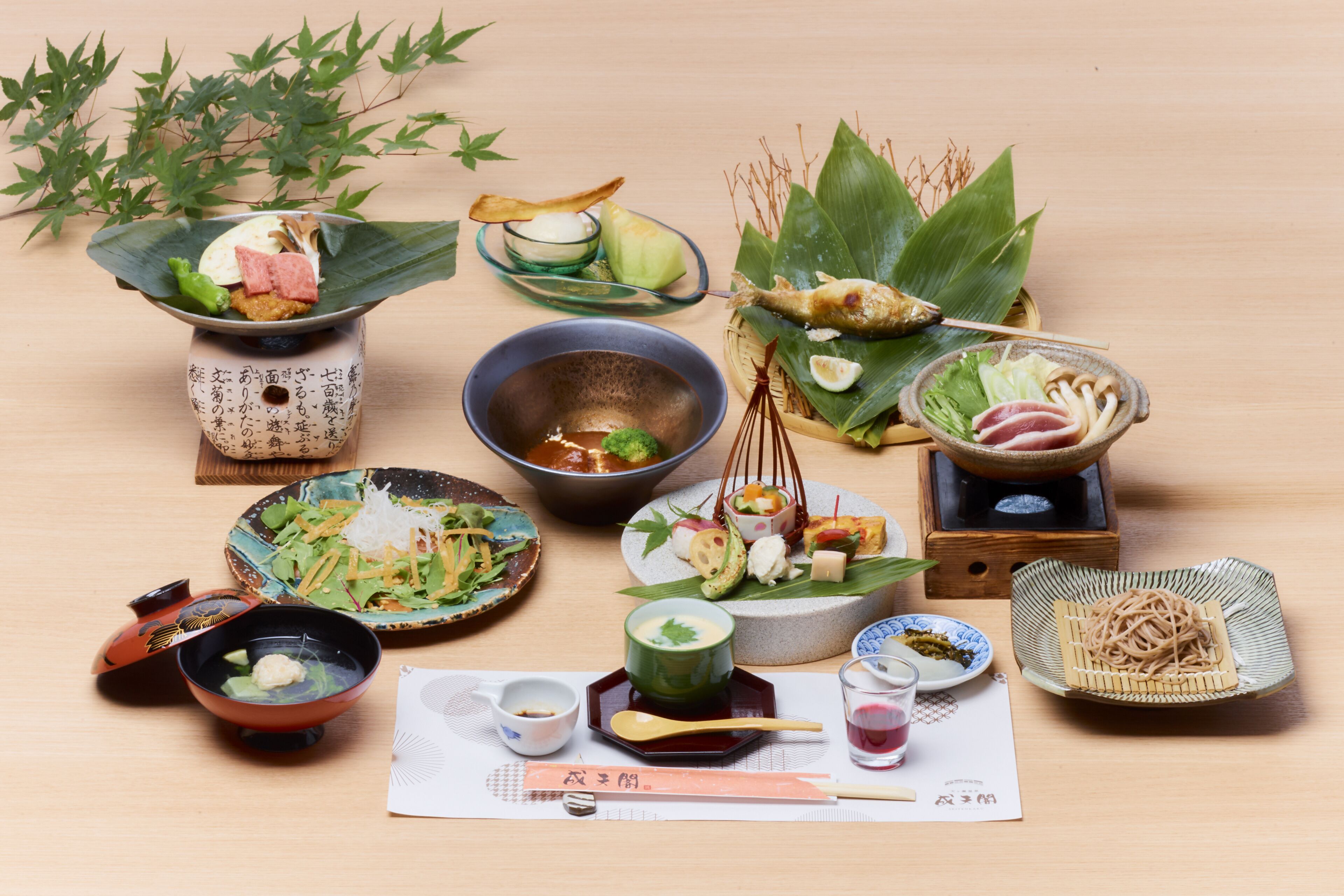 Diversitat de plats tradicionals japonesos disposats sobre una taula de fusta.