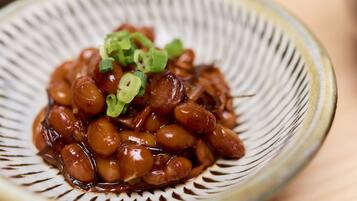A bowl of glazed beans garnished with green onions.