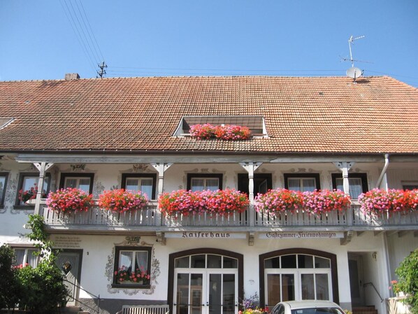 A traditional building with a tiled roof, multiple balconies with flower boxes, and a sign indicating it is a "Kaffeehaus." - Pension Kaiserhaus (Uehlingen-Birkendorf)