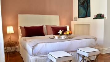 A neatly arranged bedroom with a large bed, two bedside tables, and a tray with breakfast items.