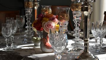 A table set with various glassware and a vase of flowers.