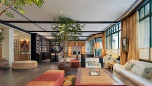 A spacious lobby with a reception desk, seating area, and large windows. - H10 Casa de la Plata (Seville)
