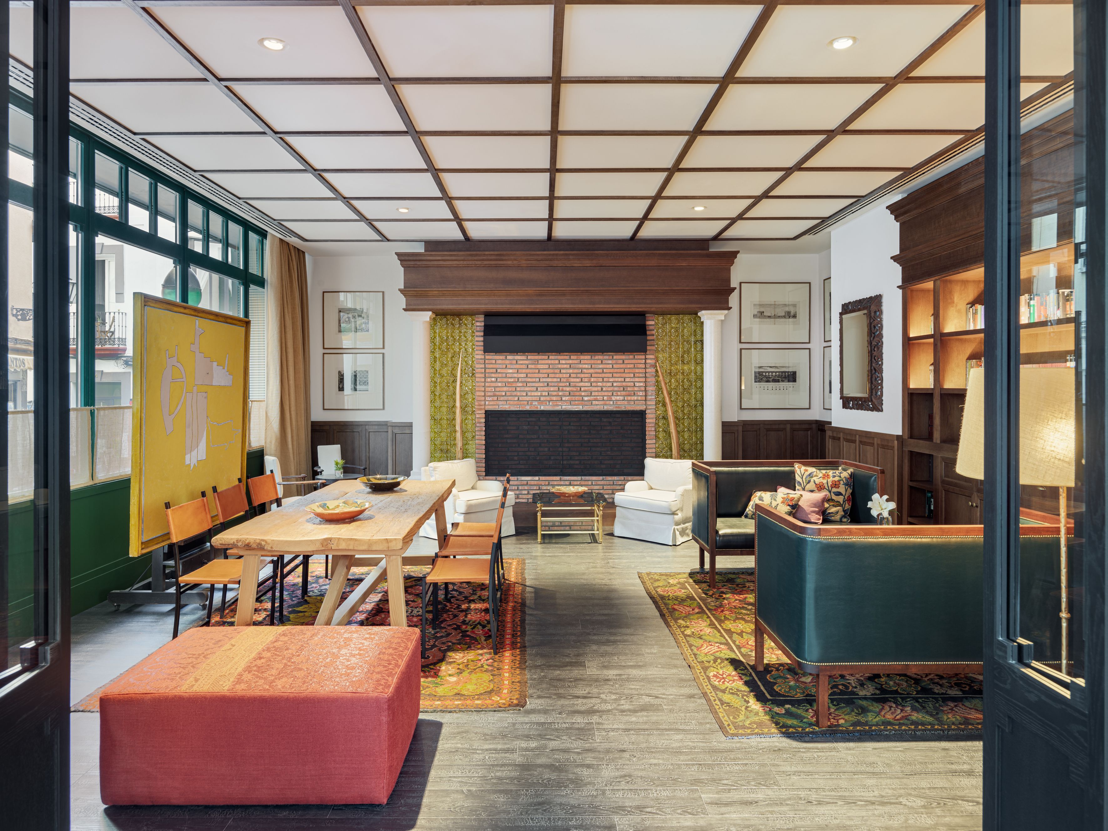 A spacious living room with a fireplace, comfortable seating, and a large window.