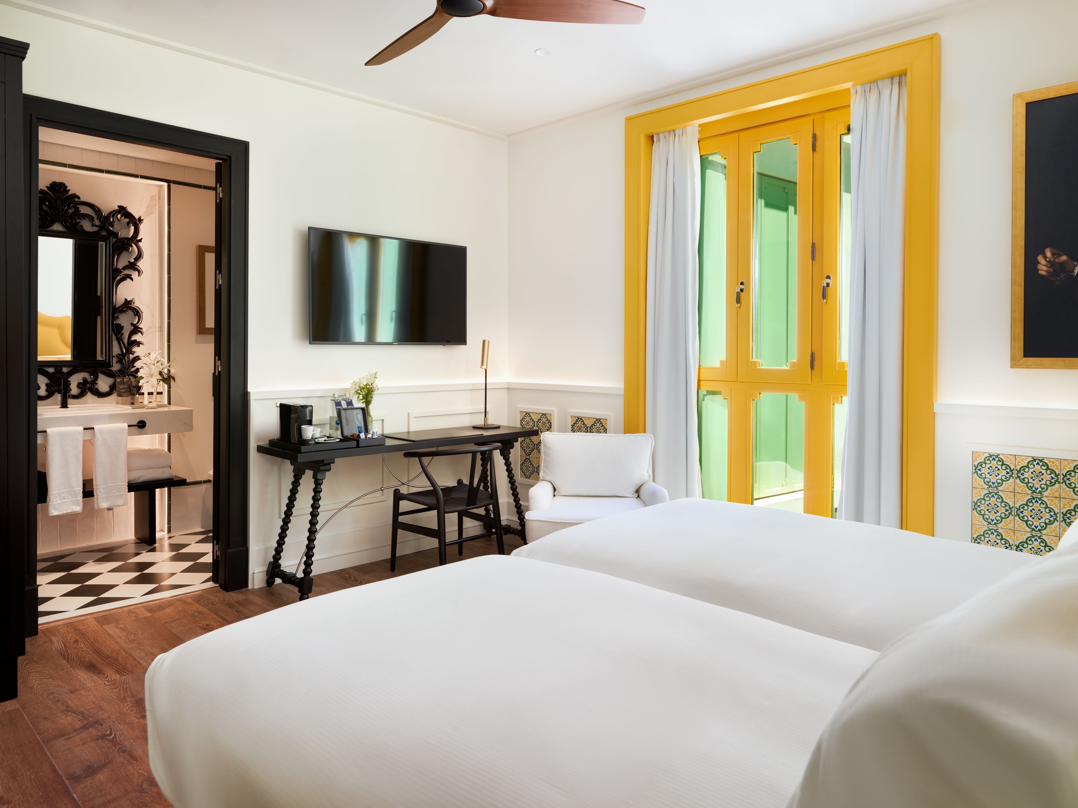Una habitación de hotel con cama, escritorio y televisión.