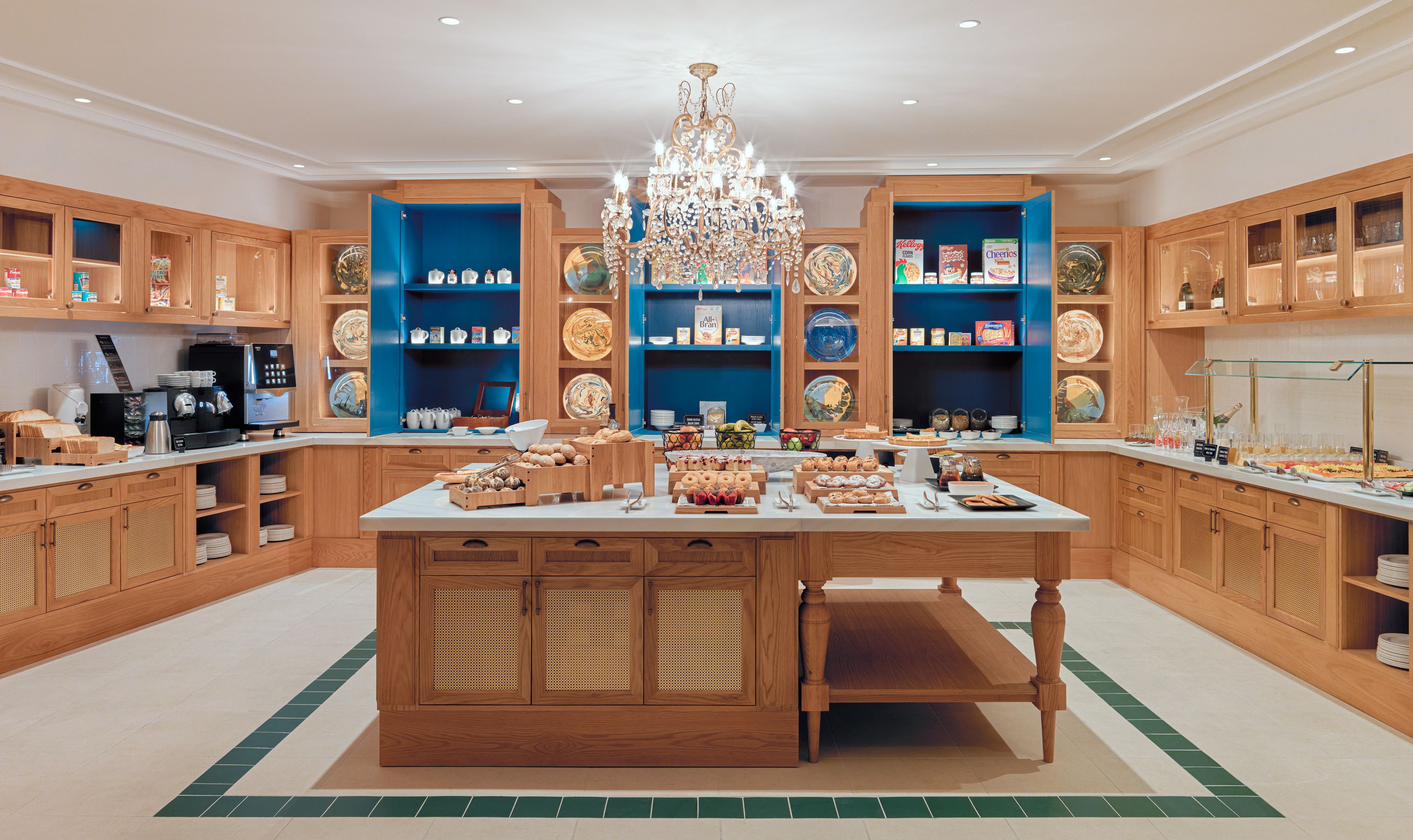 A spacious kitchen with wooden cabinets, a central island, and a chandelier.