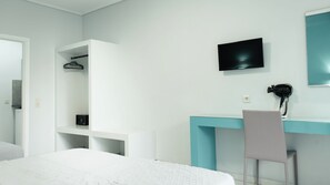 A modern bedroom with a bed, a desk, and a chair. - Timos Hotel (Zakynthos)