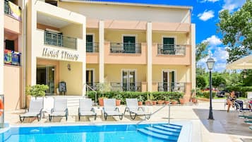 Una piscina al aire libre, sombrillas, sillones reclinables de piscina
