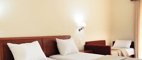 A hotel room with two beds, a nightstand, a lamp, and a window with curtains.