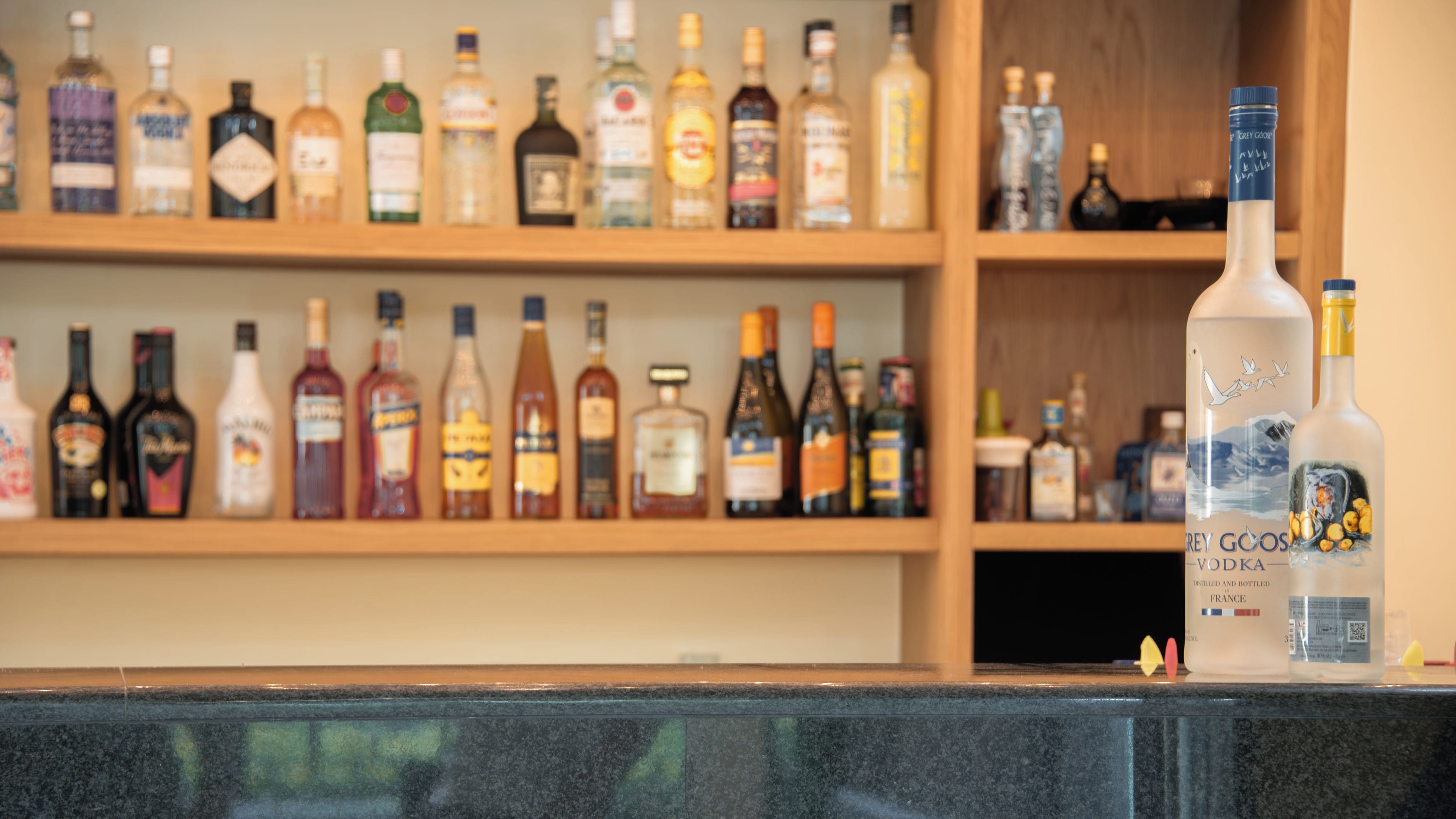 A bar area with shelves of various liquor bottles.
