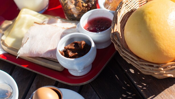A breakfast tray with various foods and drinks on a wooden table. - Hôtel Plein Ciel (Champery)