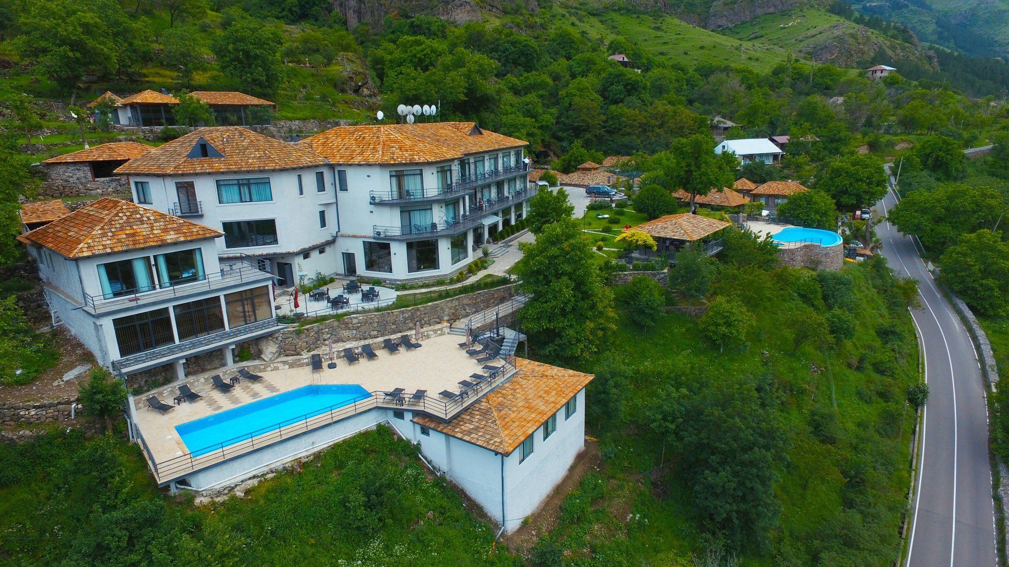 A large, multi-story building with a swimming pool and outdoor seating area.