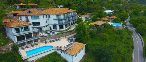 A large, multi-story building with a swimming pool and outdoor seating area.