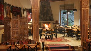 Una posada tradicional con muebles de madera, una chimenea de piedra y vistas al exterior.