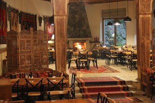 Una posada tradicional con muebles de madera, una chimenea de piedra y vistas al exterior.