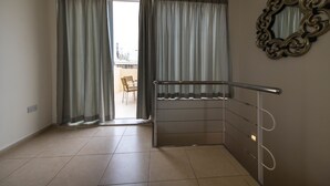 A room with a balcony, a metal railing, and a decorative mirror on the wall. - Vacation Rentals (St. Paul's Bay)