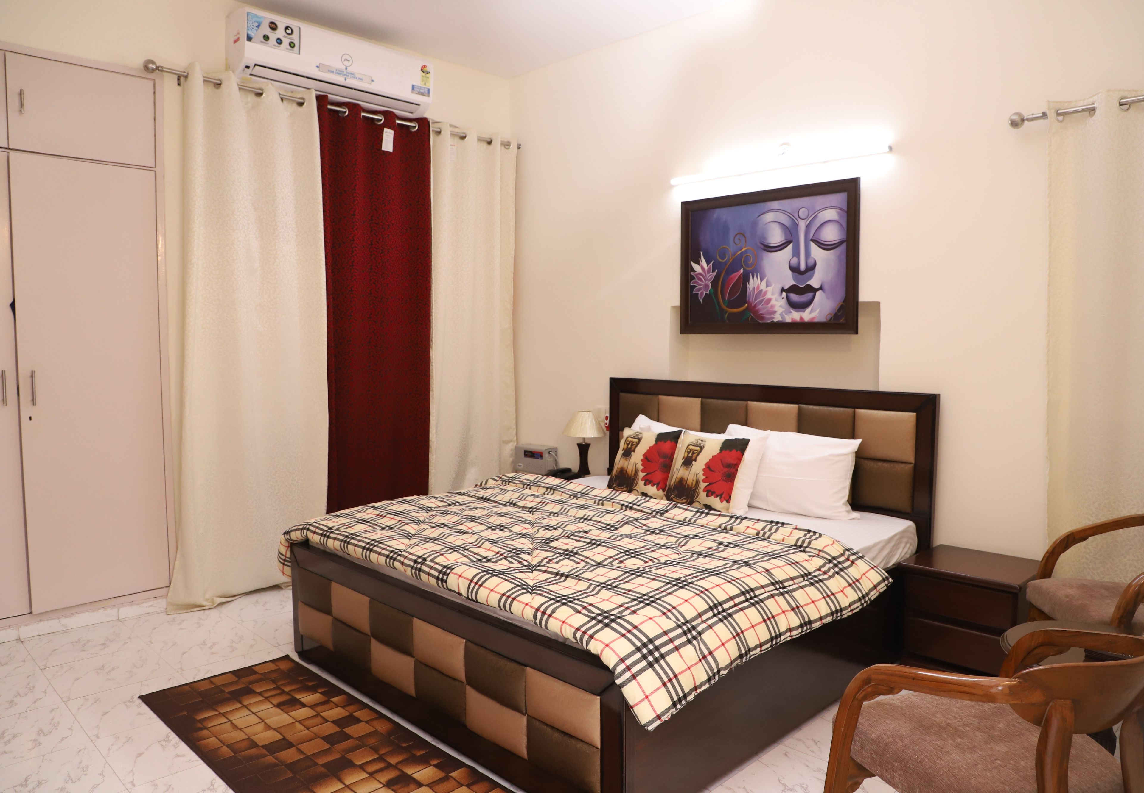 A bedroom with a bed, nightstands, a chair, a wardrobe, and a painting on the wall.