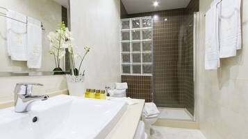 Un baño moderno con una bañera grande, una ducha y un inodoro.