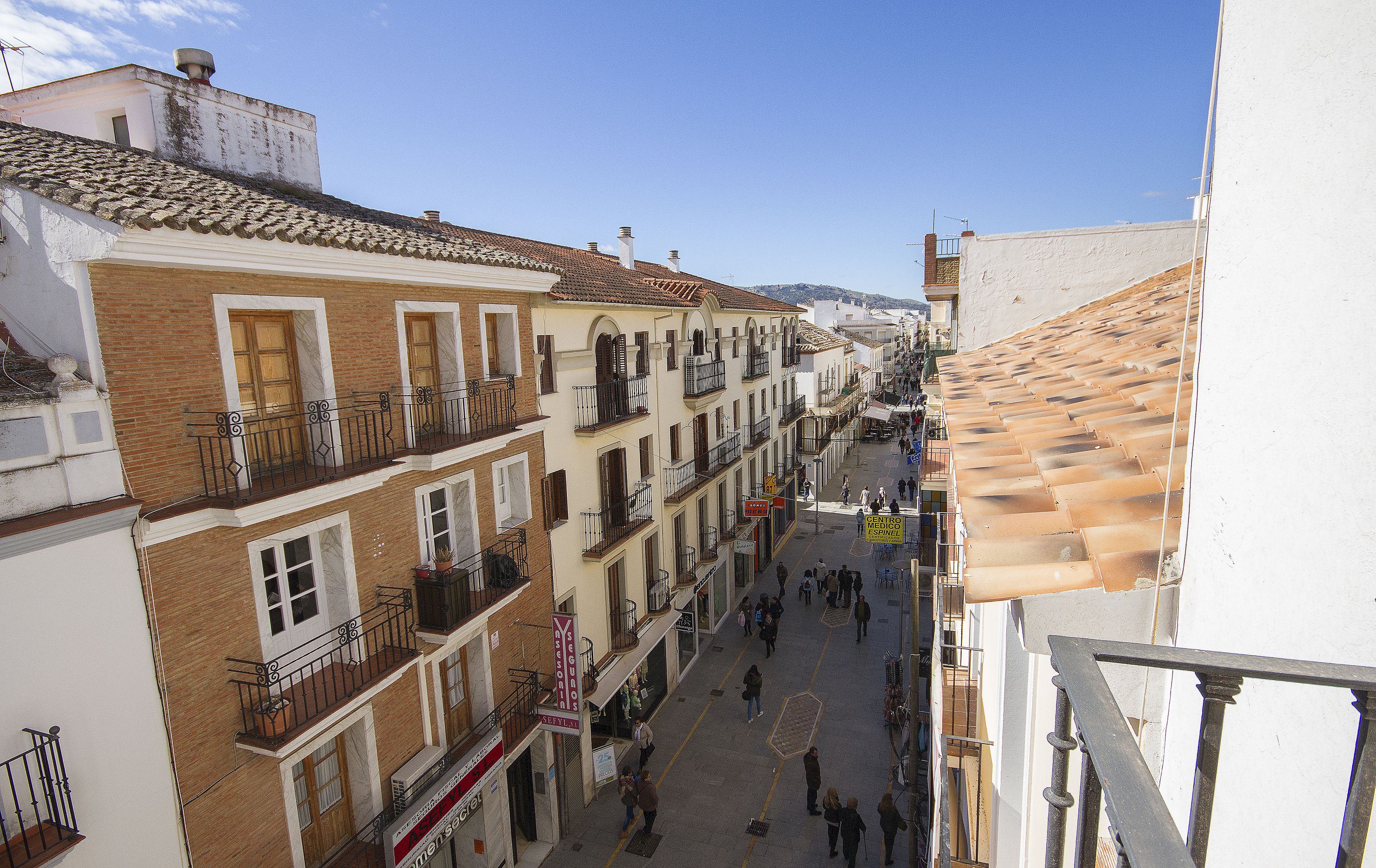 A narrow street lined with multi-story buildings, featuring balconies and traditional architecture.
