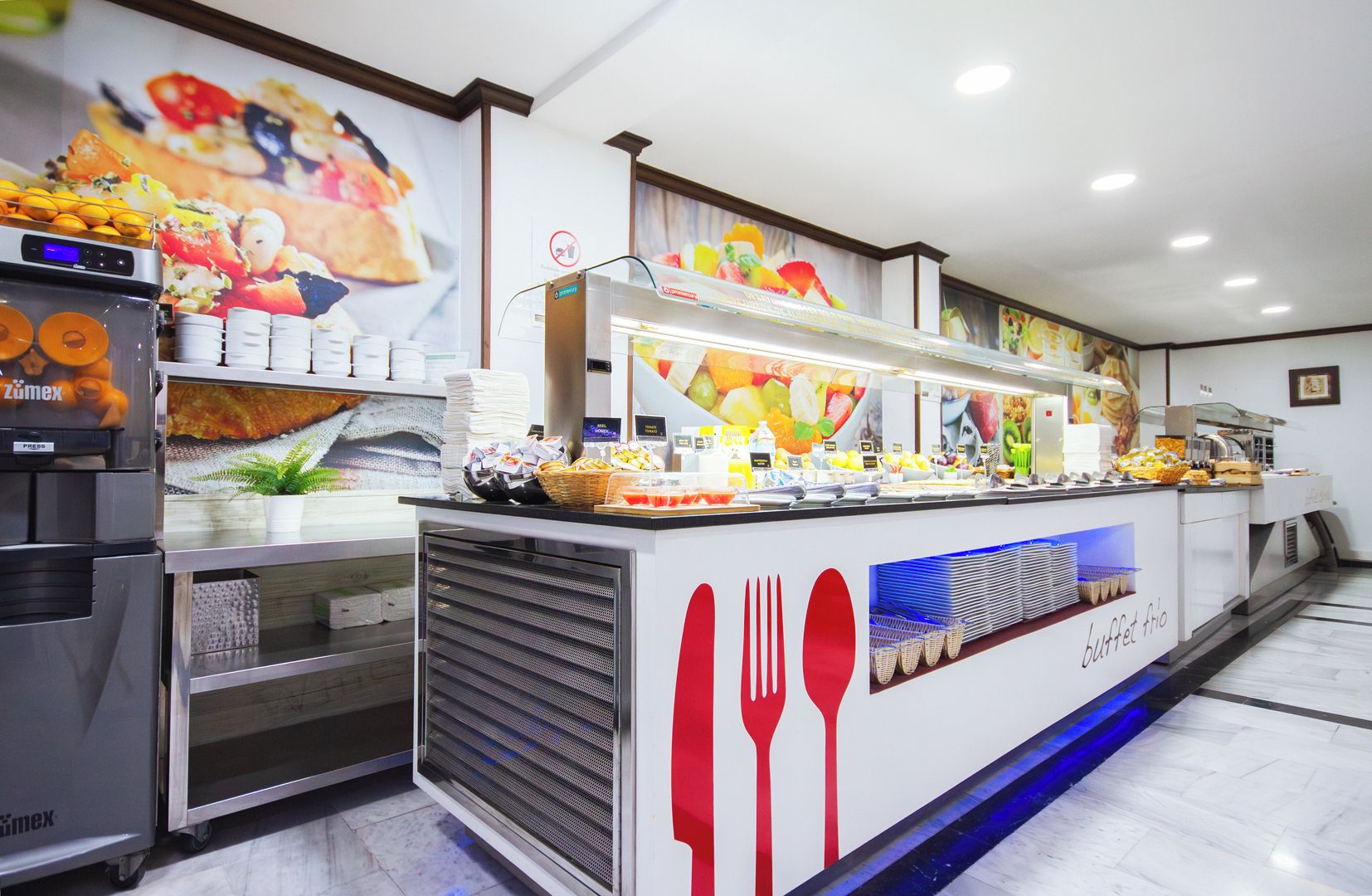 A buffet setup with various food items and utensils.