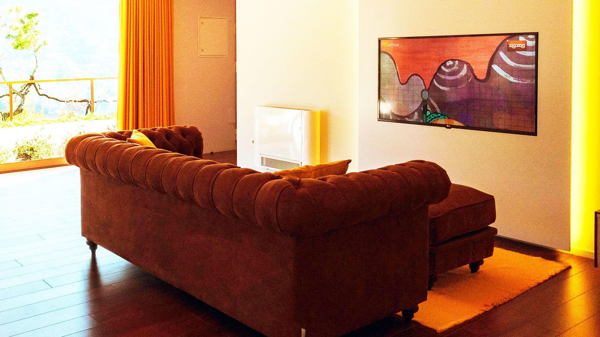 Un salón moderno con un sofá marrón, una mesita y un cuadro en la pared.