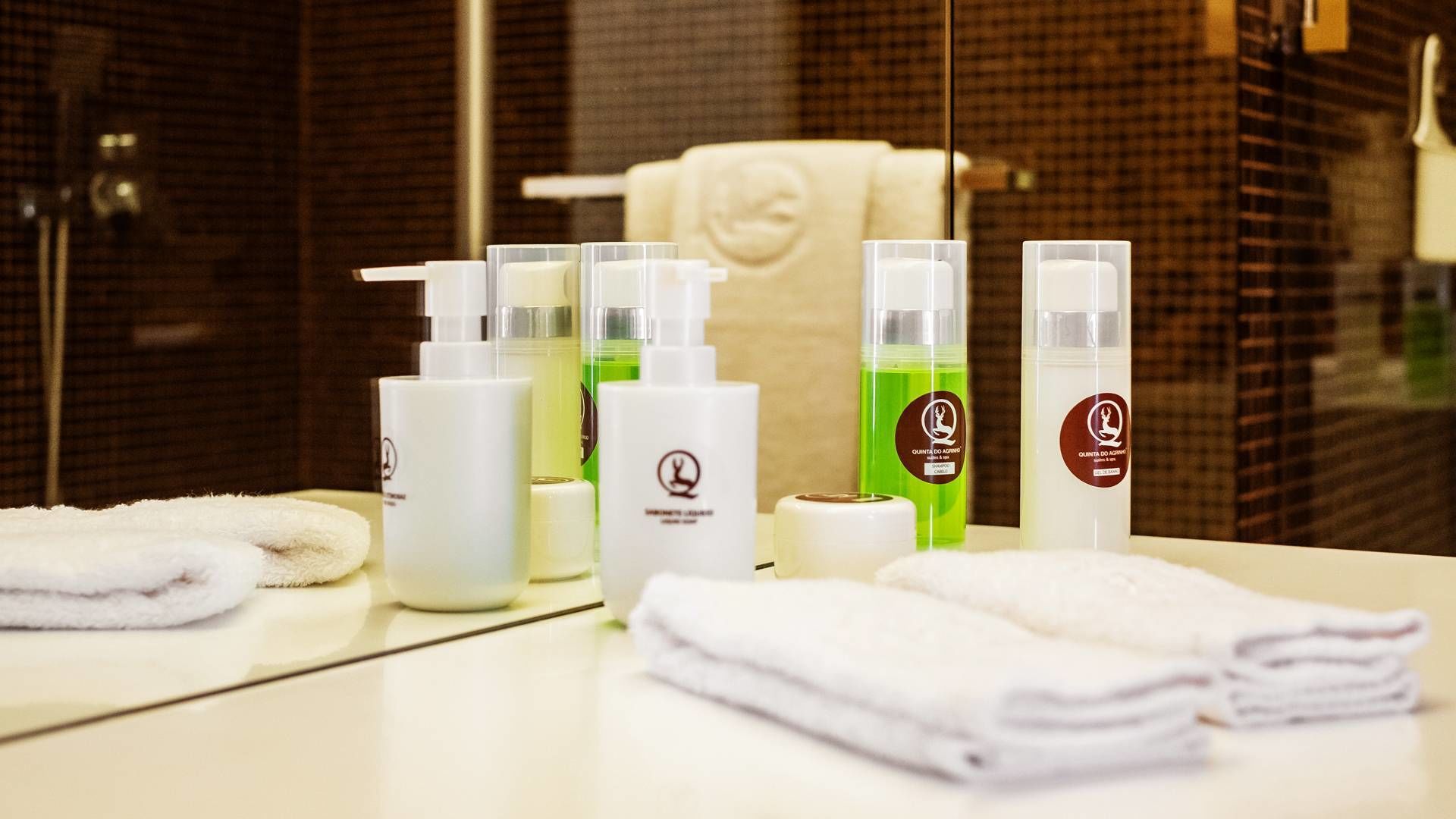 A bathroom with toiletries, towels, and a mirror.