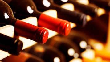 A close-up of wine bottles with red and black labels, arranged in a row.