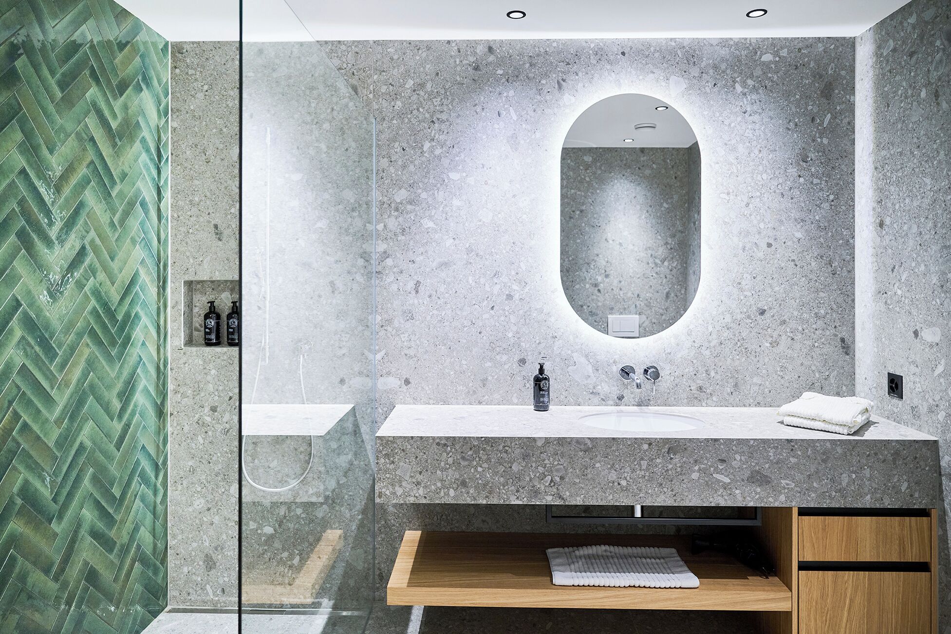 A modern bathroom with a large mirror, a sink, and a shower area.