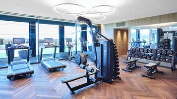 Un gimnasio moderno con cintas de correr, elípticas y equipo de levantamiento de pesas.