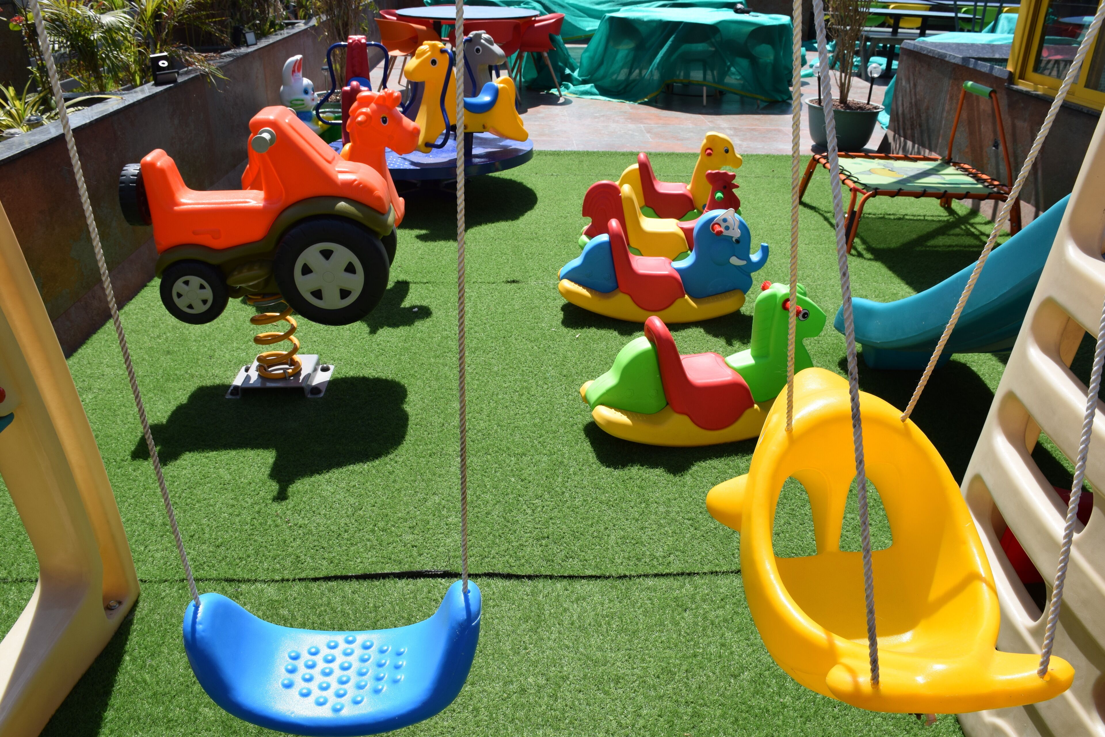 Un parque infantil con columpios, tobogán y diversas estructuras de juego coloridas.