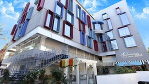 Un hotel moderno con una estructura de varios pisos, una escalera visible y un letrero que dice 'Hummingbird Hotel & Banquet'.