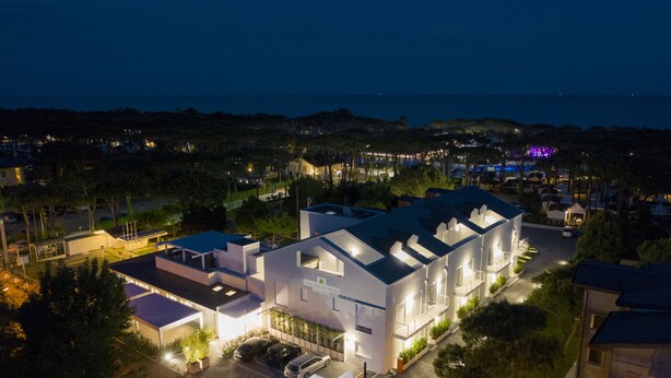 A modern hotel with multiple buildings, parking, and a view of the sea. - The Green Park Hotel (Cavallino-Treporti)