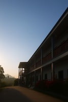Un edificio de varios pisos con un patio central, balcones y techo plano.