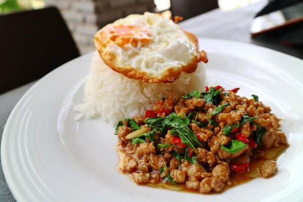 A plate with white rice, a fried egg, and a dish of minced meat with vegetables.