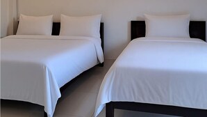 Two single beds with white bedding in a hotel room. - Sipanya Guesthouse (Phonsavan)