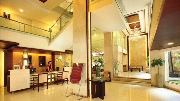 A hotel lobby with a reception desk, seating area, and a staircase. - Broad Bean Cochin (Kanayannur)