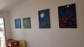 Una habitación con cuatro cuadros en la pared, un escritorio de madera y una silla.