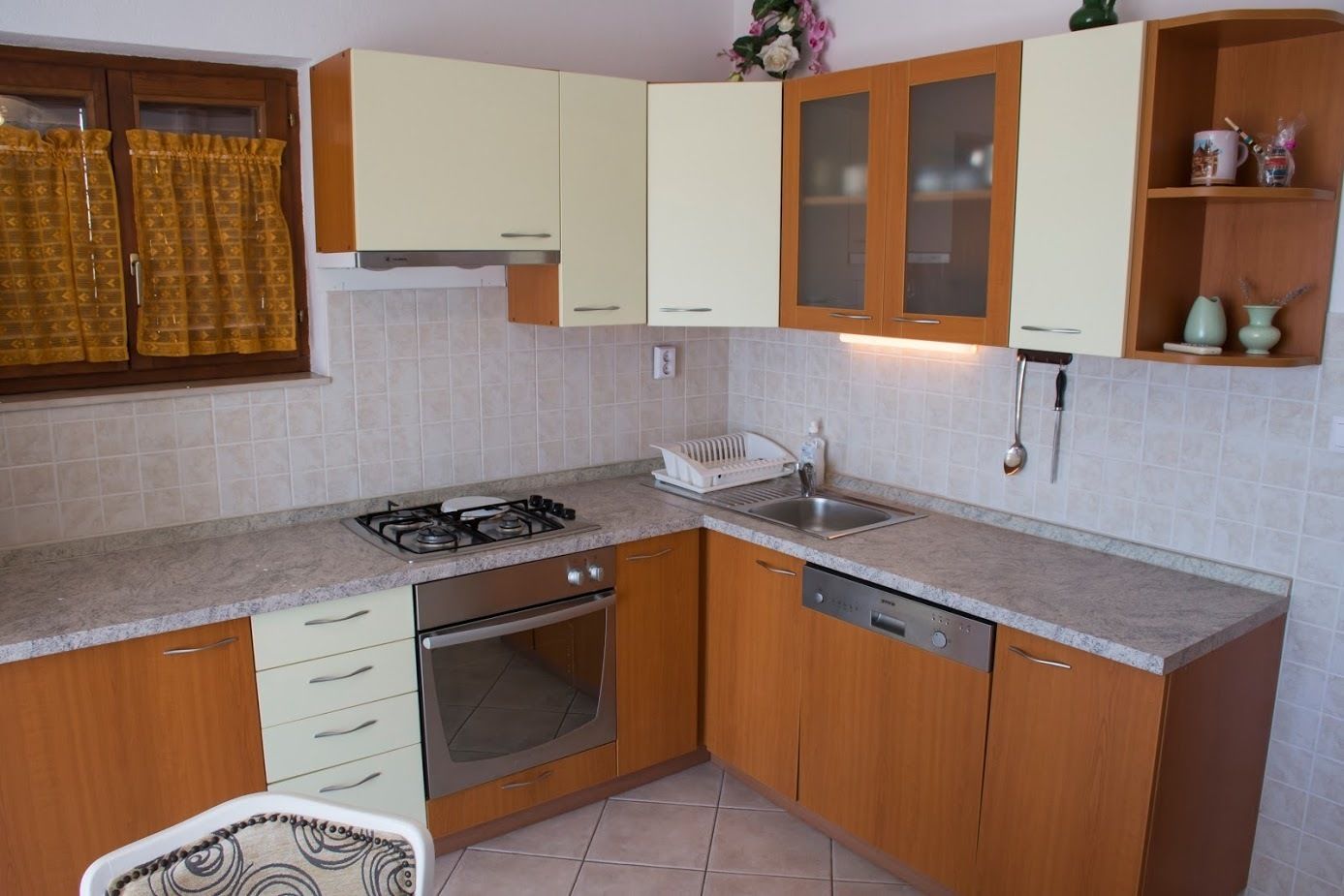 A compact kitchen with a gas stove, oven, dishwasher, and a sink.