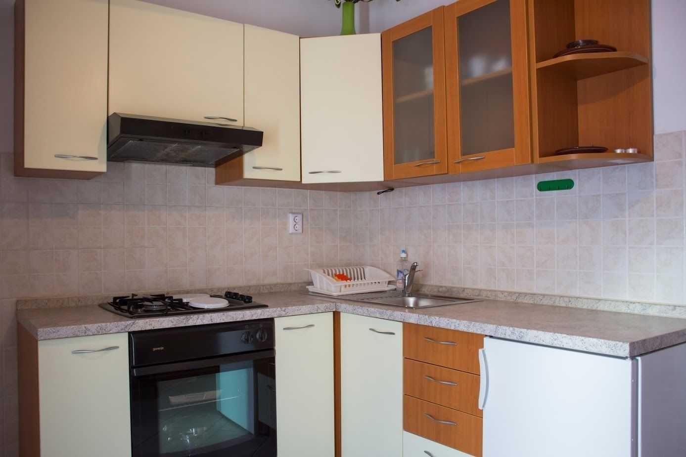 A compact kitchen with a gas stove, oven, dishwasher, and wooden cabinets.