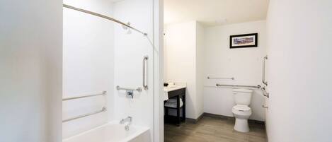 Een moderne badkamer met een bad, toilet en douche.