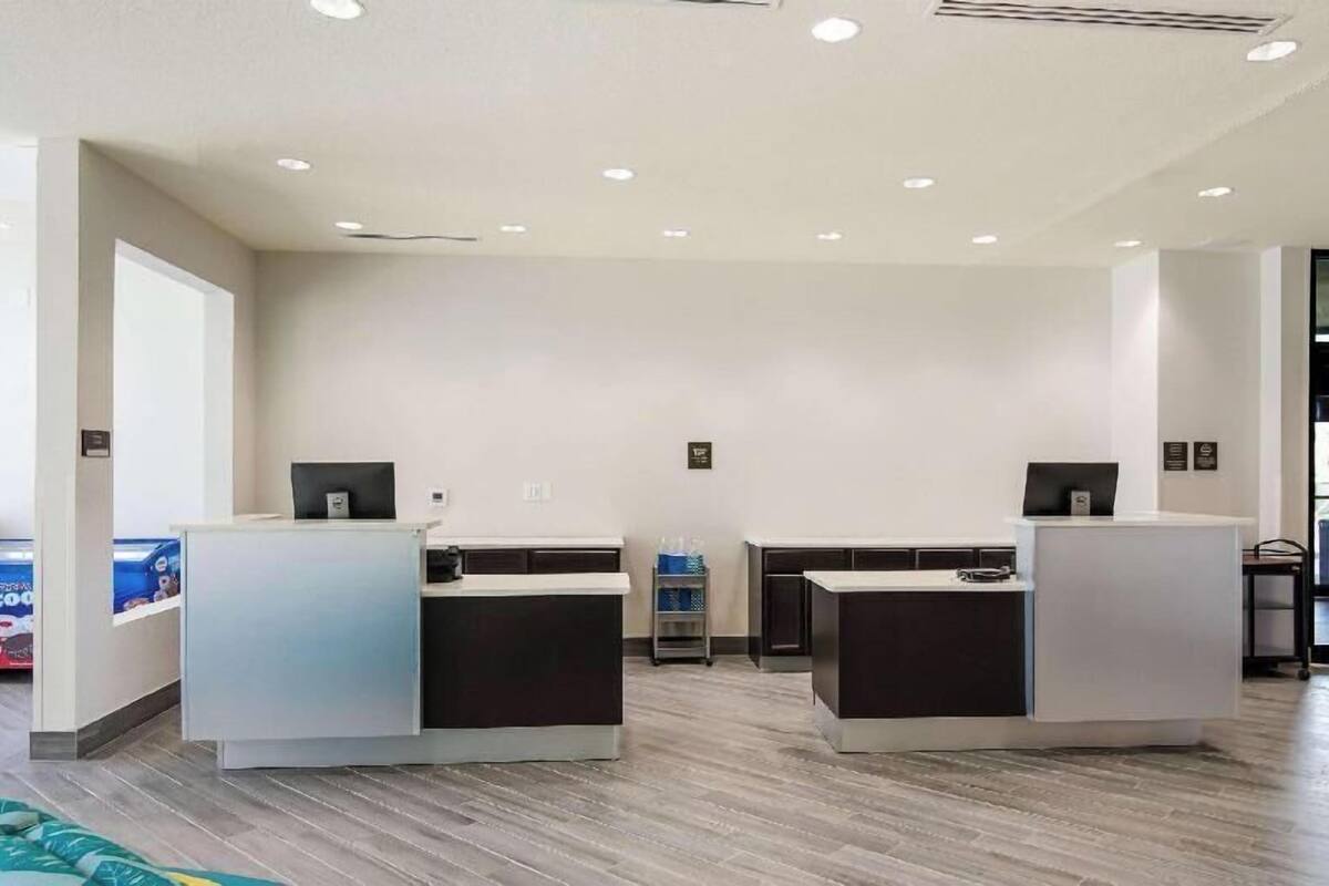 A reception area with two counters, a wall-mounted sign, and a cart with items.
