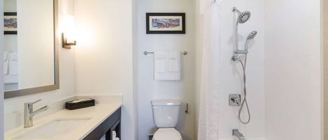 Un baño con lavamanos, inodoro y ducha.